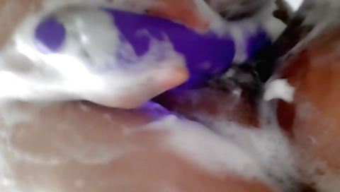 Busty girl enjoys a hot shower with a dildo and rod